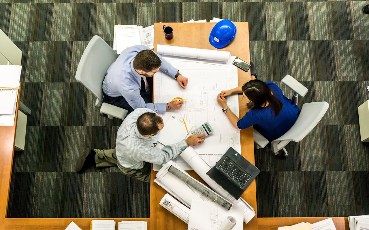 executives at table looking at construction blueprints